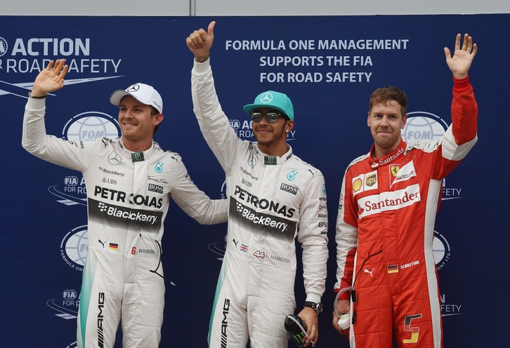 Hamilton junto a Vettel y Rosberg. (Greg BAKER / AFP)