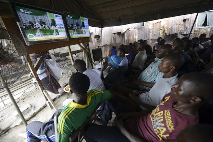 Nigerianos sigue por televisión la información sobre el escrutinio electoral. (Pius Utomi EKPEI / AFP) 