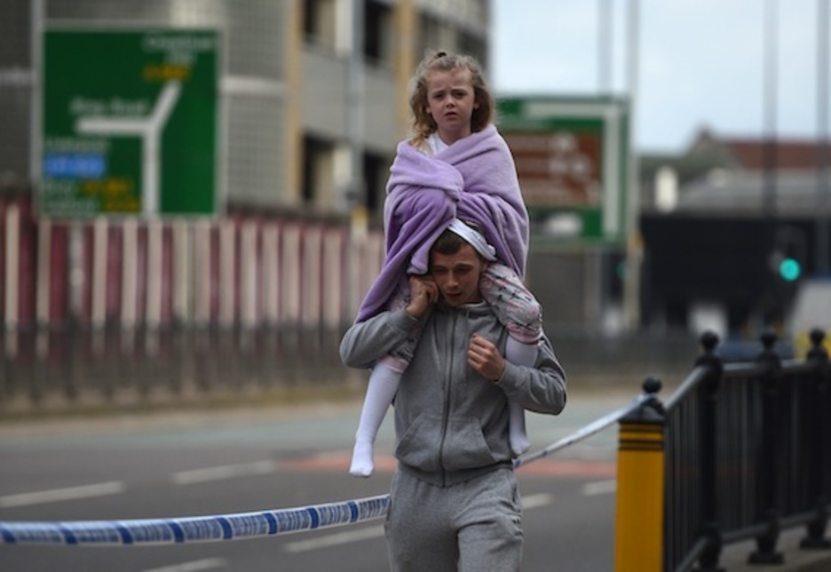 Un hombre lleva a hombros a una niña cerca de la Estación Victoria de Manchester. (Oli SCARFF/AFP)