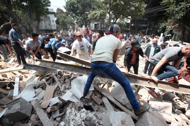 Un grupo de personas retira los escombros de un edificio de Ciudad de México. (Alfredo ESTRELLA/AFP)
