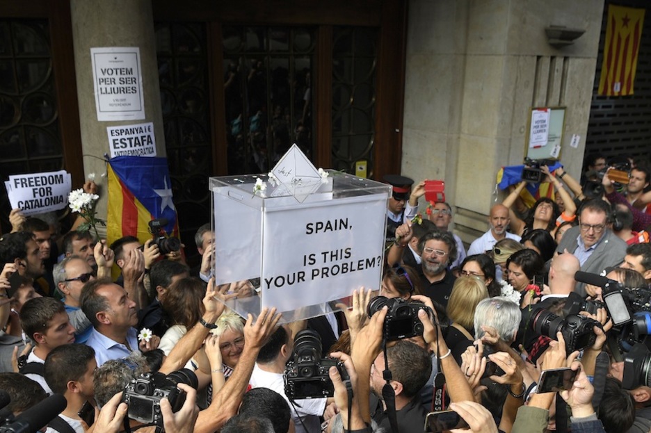 La multitud sostiene una urna ante la Conselleria de Economía. (Lluis GENE/AFP)