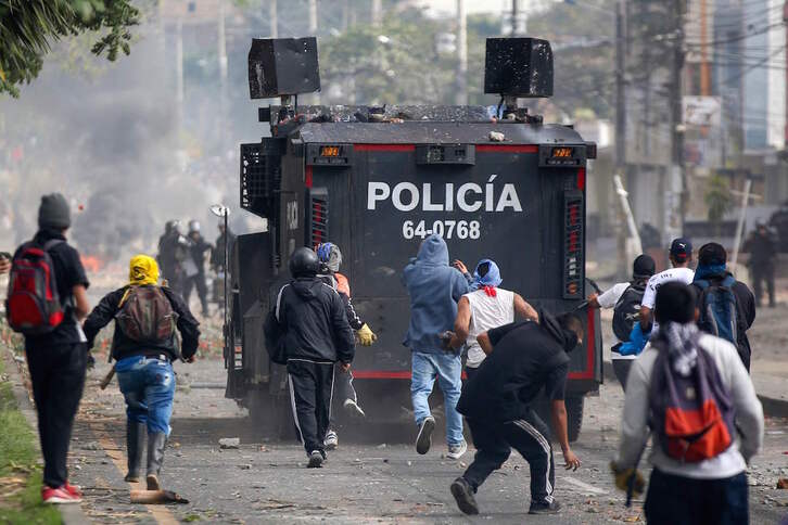 Los manifestantes apedrean un vehículo policial durante los enfrentamientos en Popayán. (Julián MORENO/AFP)