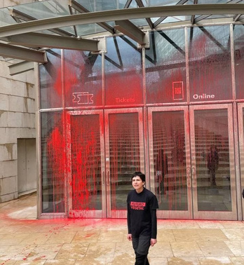 Activista de Futuro Vegetal junto a la entrada del Museo Guggenheim con pintura en la fachada.