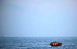 Imagen de archivo de un grupo de personas en un bote inflable tratando de llegar a Dover a través el canal de la Mancha.