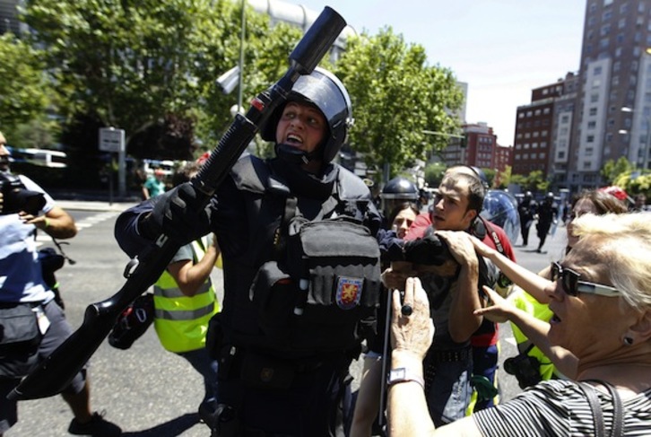 Un agente de la Policía, pertrechado con material antidisturbios, durante la carga. (César MANSO/AFP PHOTO)