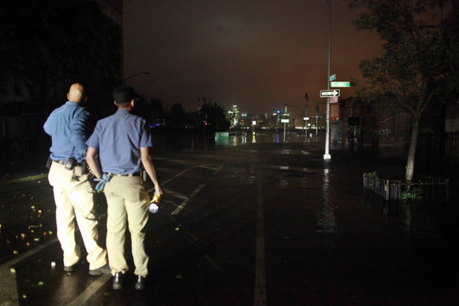 Efectivos de emergencias cierran una avenida a la vista de la subida del nivel del agua. (Allison JOYCE/AFP)