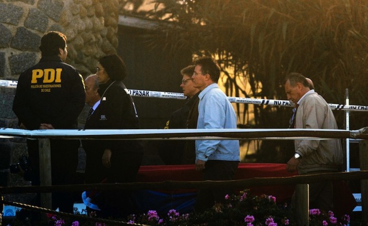 Parientes de Neruda y miembros de la comitiva judicial trasladan los restos del poeta en un ataúd. (Martin BERNETTI/AFP) 