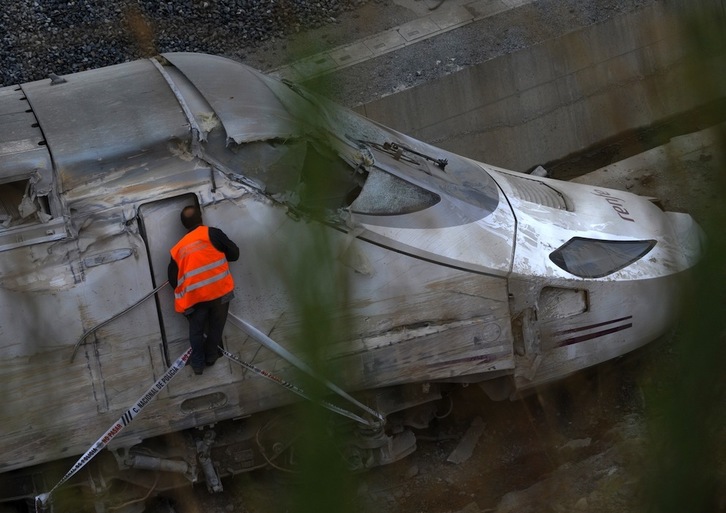 Un miembro de los equipos de rescate mira dentro de la locomotora. (Miguel RIOPA/AFP)