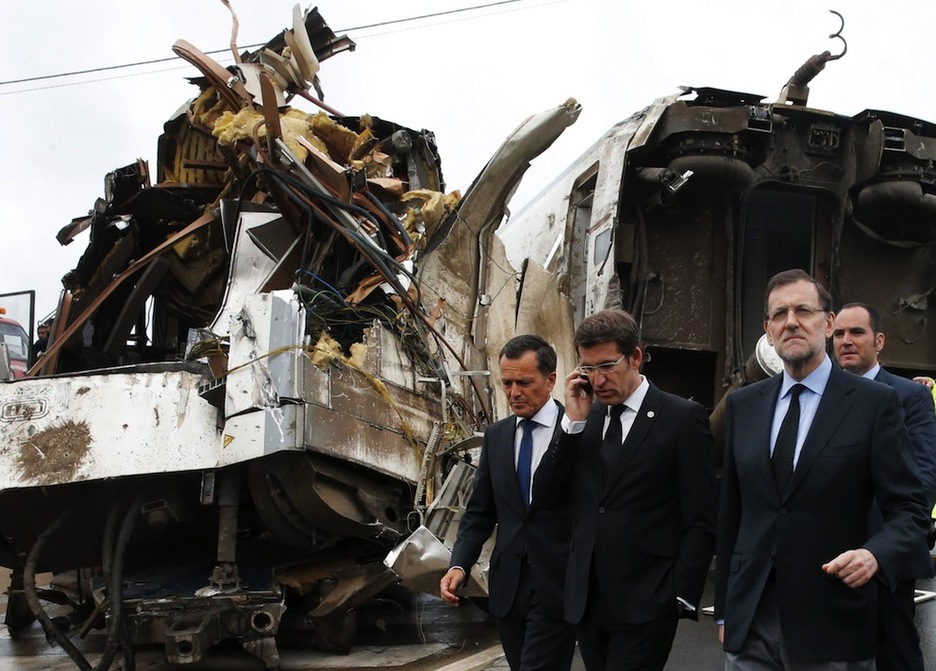 Rajoy y Núñez Feijóo, con uno de los vagones siniestrados tras ellos. (LAVANDEIRA/AFP)