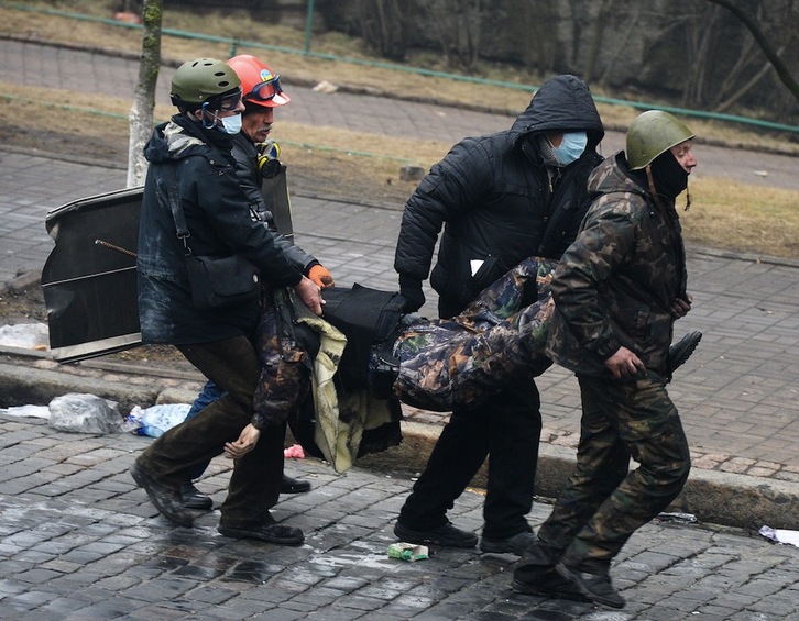 Varios opositores trasladan a un hombre herido durante los enfrentamientos en Kiev. (Dmitry SEREBRYAKOV/AFP)