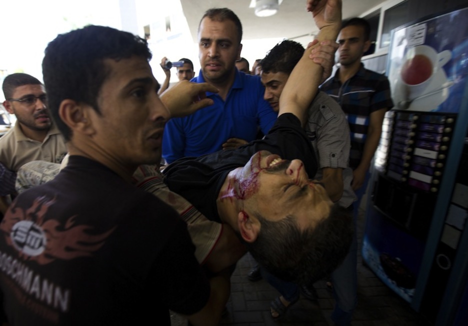 Ciudad de Gaza. Varias personas trasladan a un herido al hospital. (Mohammed ABED/AFP)