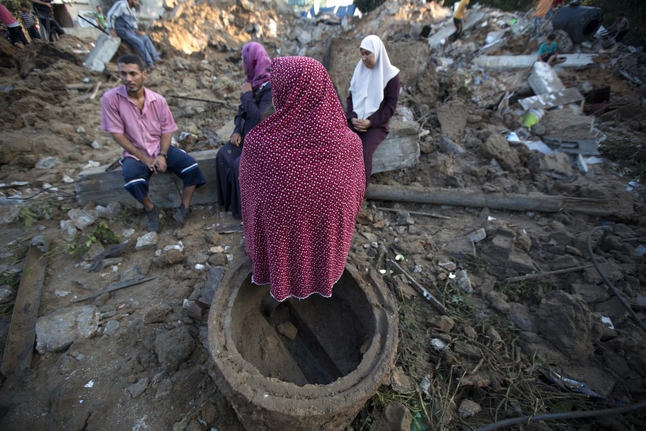 Un grupo de palestinos entre los escombros de una vivienda en Beit Hanun. (Mohammed ABED/AFP)