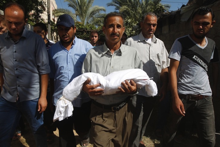 Un palestino sostiene el cadáver de su hijo en su funeral. (Said KHATIB/AFP) 