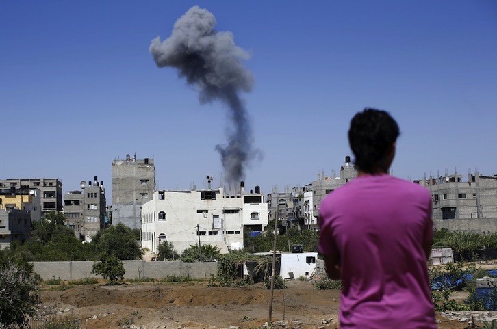 Un hombre observa el impacto de misiles israelíes sobre unas viviendas en Gaza. (Thomas COEX/AFP)