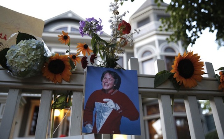 Flores y una antigua foto en recuerdo a Robin Williams. (Marc PISCOTTY / AFP)  (