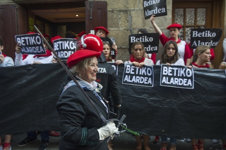 Izaskun Larruskain, capitana de la compañía Jaizkibel, pasa frente un ertzaina y defensoras del alarde discriminatorio. (Jon URBE/ARGAZKI PRESS)