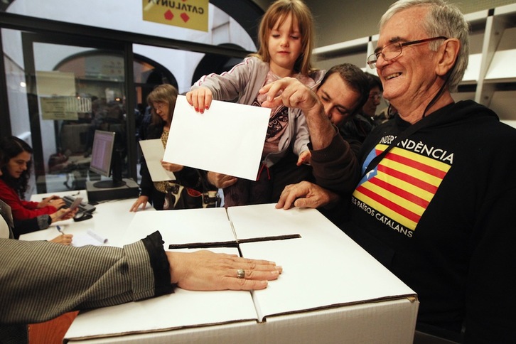 Un hombre vota con su hija en Perpinyà, Catalunya norte, durante la consulta del 9N. (Raymond ROIG/AFP) 