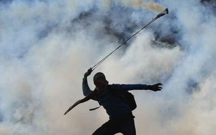 Palestinar gazte bat atzo soldadu israeldarren gas negareragiledun ontzia soldaduei «itzultzen». (ABBAS MOMANI  / AFP)