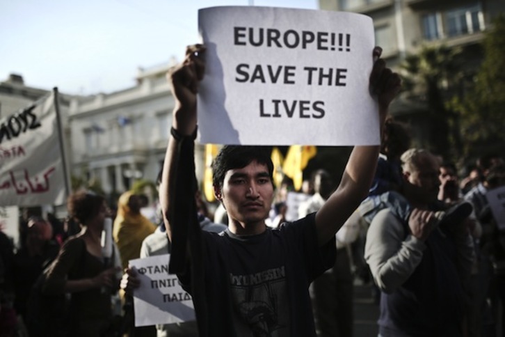 Un hombre sostiene un cartel que apela a Europa a salvar vidas, en Atenas. (Angelos TZORTZINIS/AFP PHOTO)