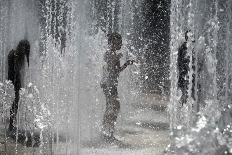 Un niño se refresca en una fuente de Lyon. (Jean-Phillipe KSIAZEK/AFP)