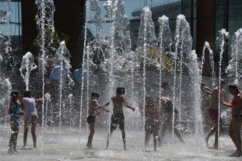 Niños juegan en una fuente de París. (Dominique FAGET/AFP) 