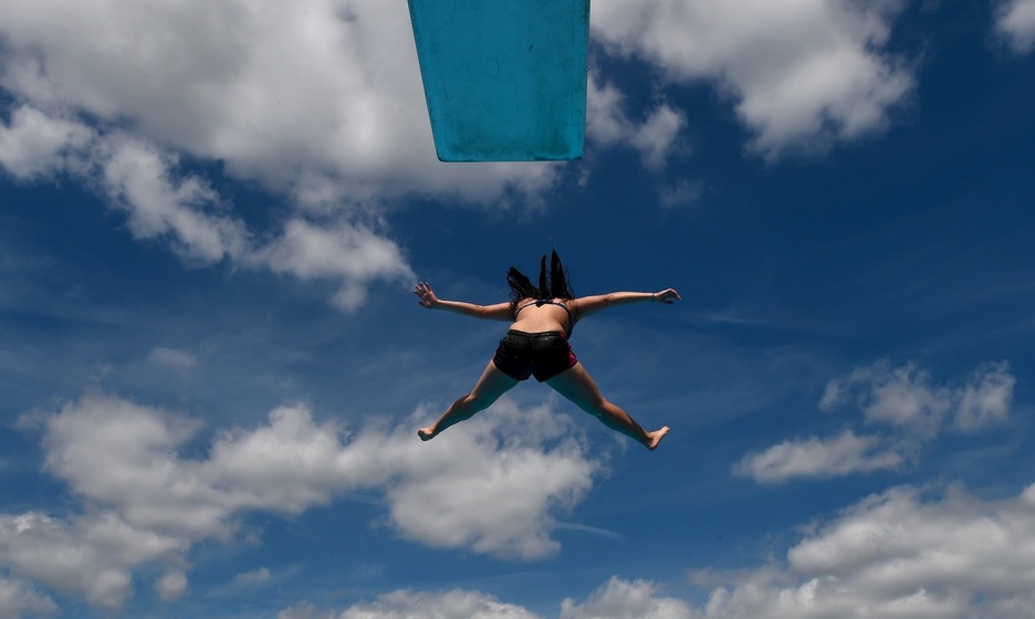 Una mujer salta de un trampolín en una piscina de Neumünster, Alemania. (Carsten REHDER/AFP)