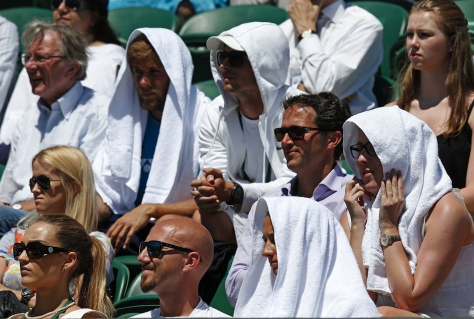 Espectadores se cubre con toallas para hacer frente al calor en el torneo de Wimbledon. (Adrian DENNIS/AFP) 