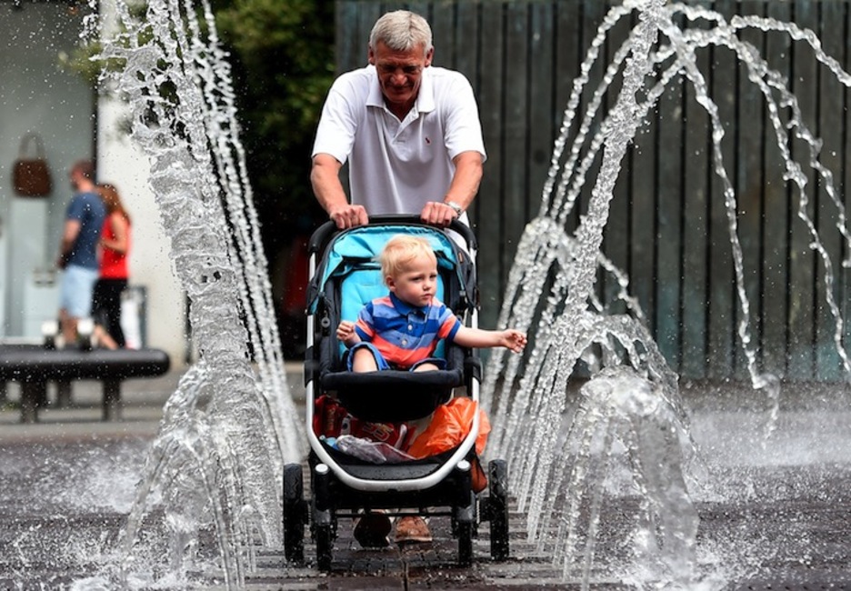 Un hombre pasea con su hijo en Liverpool. (Paul ELLIS/AFP) 