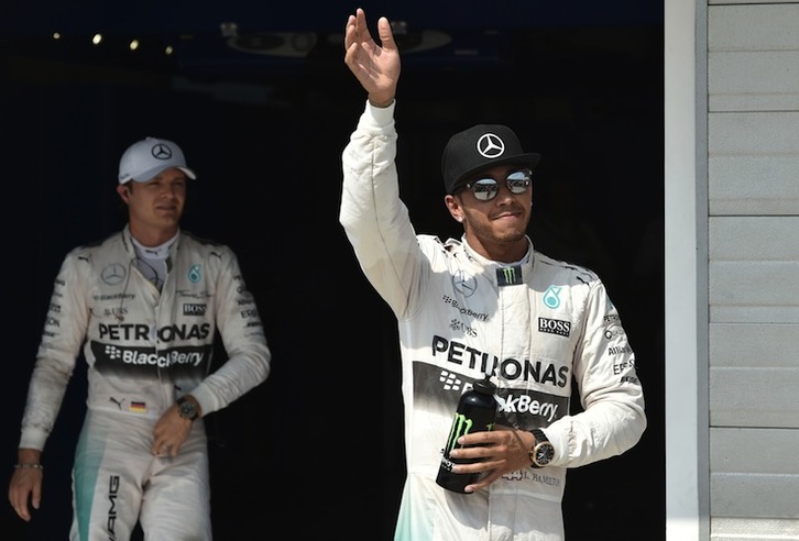 Hamilton saludan con su compañero y rival Rosberg detrás. (Andrej ISAKOVIC / AFP)  