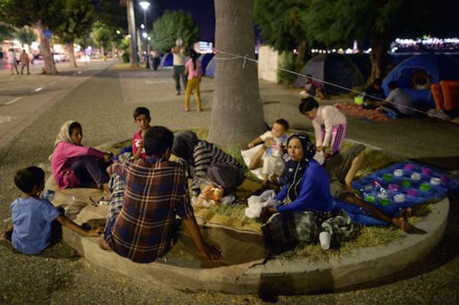 Afganistango familia bat Kos hirian, bazter batean lotarako prestatzen. (Louisa GOULIAMAKI | AFP)