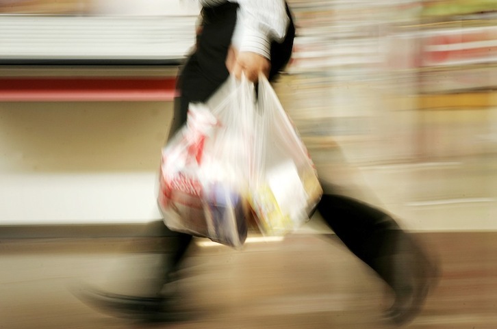 Un cliente porta varias bolsas de plástico en un comercio. (Iñigo URIZ / FOKU)