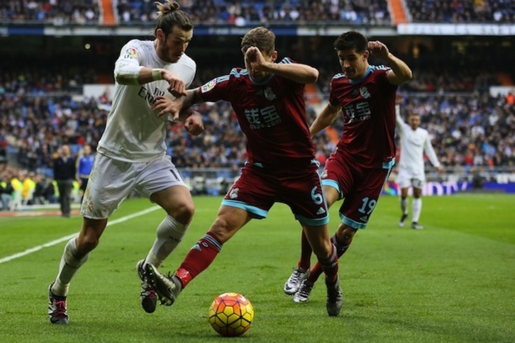 Iñigo Martínez y Yuri tratan de frenar a Bale. (César MANSO / AFP)