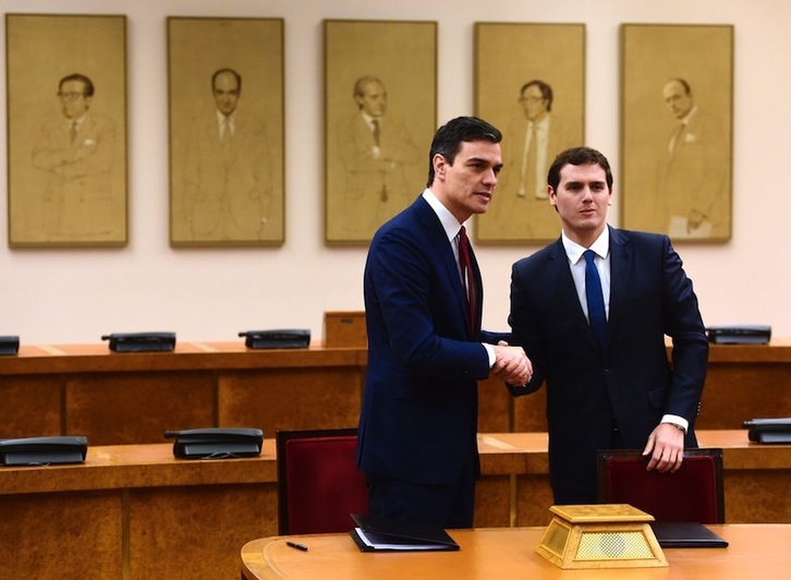 Sánchez y Rivera se dan la mano tras firmar el acuerdo. (Pierre-Philippe MARCOU /AFP)
