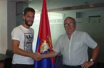 Torres se saluda con el presidente Sabalza tras firmar la ampliación de su contrato. (OSASUNA)