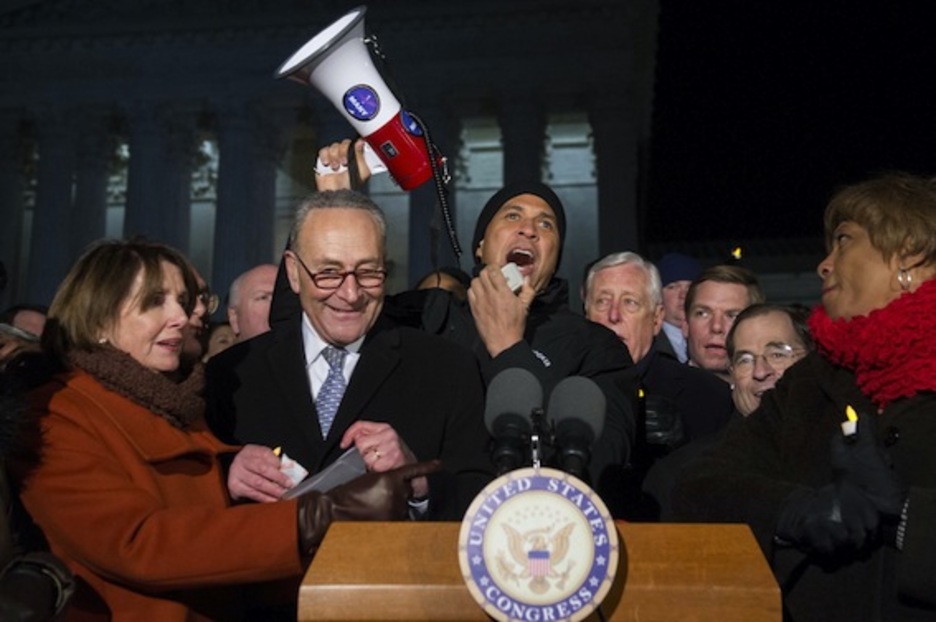 Megáfono en mano, el senador demócrata Cory Booker, denuncia los vetos de Trump a la inmigración. (Saul LOEB/AFP)