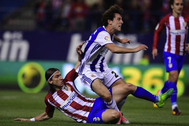 Filipe Luis, que ha marcado el gol del Atlético, derriba con una entrada a Raúl Navas. (Javier SORIANO/AFP)