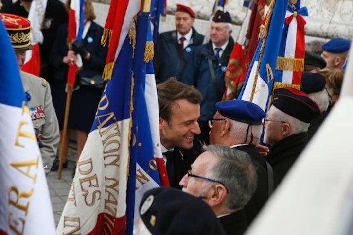 Emmanuel Macron saluda a veteranos de guerra durante el acto que conmemoraba ayer el 72 aniversario del triunfo ante la Alemania nazi. (François MORI/AFP)