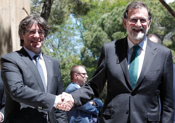 Carles Puigdemont y Mariano Rajoy se han saludado este viernes en el Salón del Automóvil de Barcelona. (Pau BARRENA / AFP)