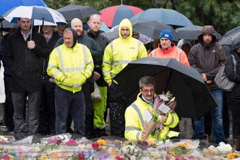 Un grupo de personas coloca flores junto al Puente de Londres. (Justin TALLIS/AFP PHOTO)