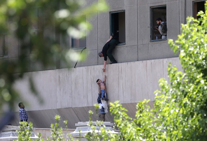 Un grupo de personas escapa del Majlis por las ventanas. (Omid VAHABZADEH)