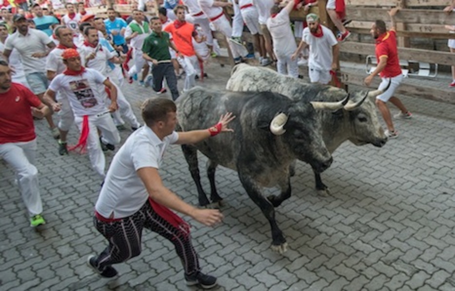 Un corredor apoya su mano en uno de los toros rezagados, gesto que está prohibido. (Andoni CANELLADA/ARGAZKI PRESS)