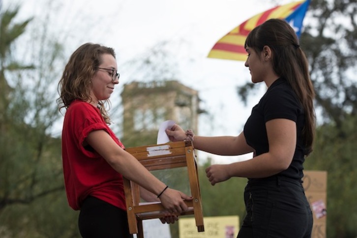 Una joven deposita de forma simbólica un voto en una urna tras la marcha estudiantil de ayer en Barcelona. (Josep LAGO/AFP)