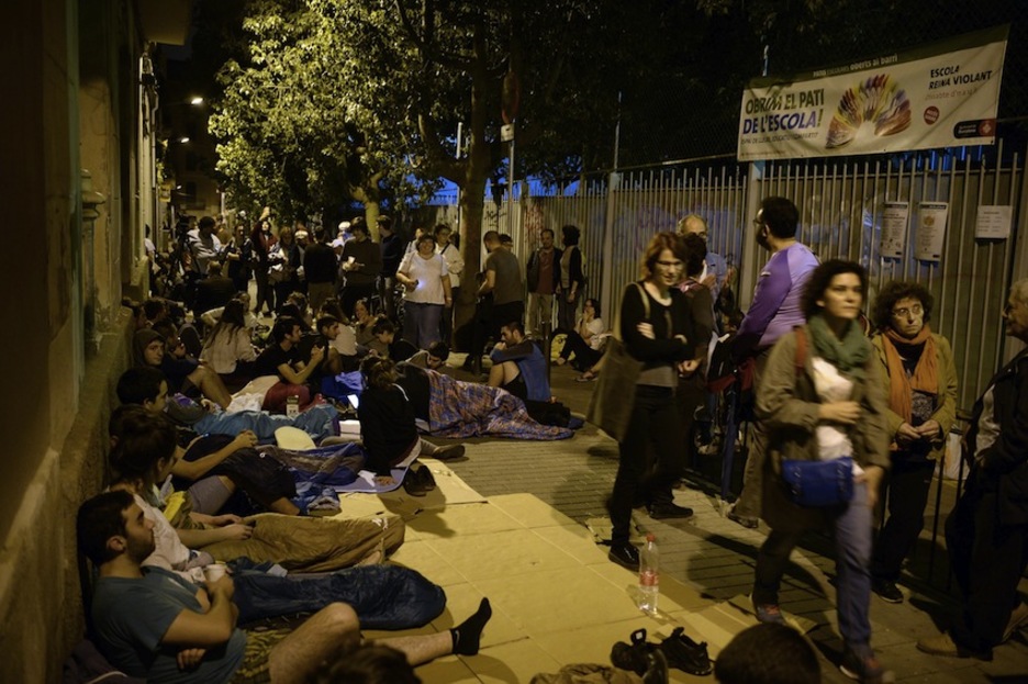 Un grupo de personas en el exterior de un colegio electoral en Barcelona. (Josep LAGO/AFP)
