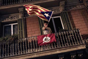 Un hombre ondea la estelada en un balcón de Barcelona. (Pau BARRENA / AFP)