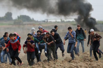 Palestinos huyen de los disparos israelíes. (Mohammed ABED/AFP)