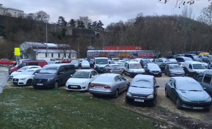 Coches y edificios en la zona de los corralillos de Iruñea, con una de capa de nieve.