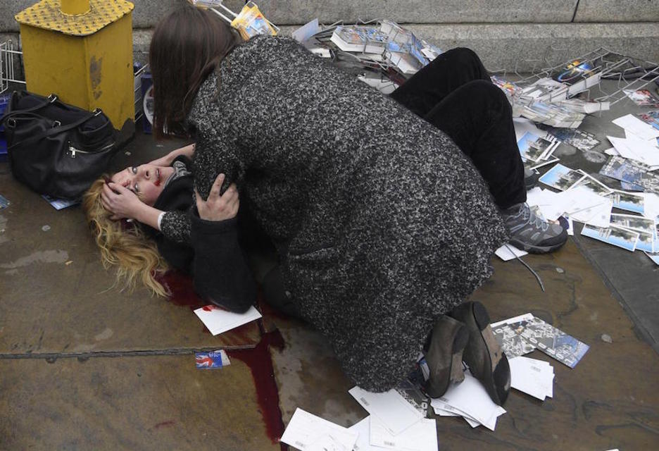 Una mujer atiende a una de las personas heridas en el atropello de Westminster. (Toby MELVILLE)