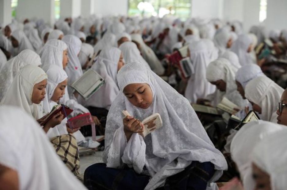 Mujeres leen el Corán en Medan, Indonesia (Ivan DAMANIK / AFP)