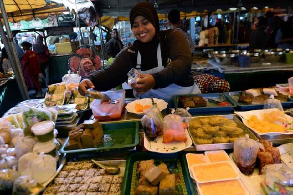 Una vendedora sonríe en su puesto de comida en Narathiwat, Tailandia. (MADAREE TOHLALA / AFP)
