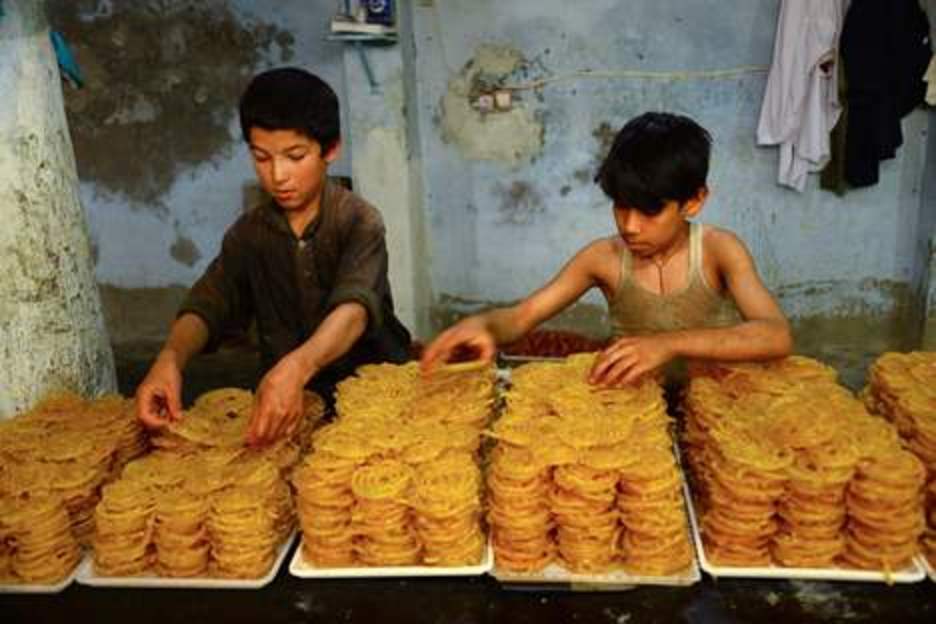 Dos niños colocan dulces en un puesto en Afganistán. (HOSHANG HASHIMI / AFP) 